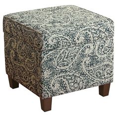 a blue and white patterned ottoman with wooden legs on an isolated white background for use as a footstool