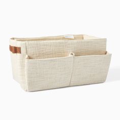 two canvas storage bins with leather handles, one in beige and the other in white