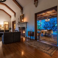 a large living room with wood floors and high vaulted ceilings is lit by lights from the windows