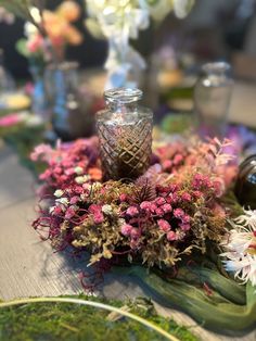 a table topped with lots of flowers and vases