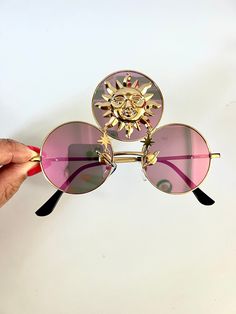 ❤️Third eye statement sunglasses by Alexis Exclusive ❤️This quirky pair of Third Eye Sunglasses are the perfect unusual accessory if you love something different. ❤️The three lenses are gold metal and they have pink mirrored lenses. In the centre lens they have a gold alloy sun with star details!  ❤️Great for festivals, carnivals, holidays, or everyday wear if that's your thing 😉 ❤️UV protection. ❤️Exclusive design made by myself, you won't see any others like these anywhere else. ❤️All my glasses come in a black pouch to keep them safe, please also handle with care. ❤️Checkout the full collection of Sunglasses here :  https://www.etsy.com/uk/shop/AlexisExclusive?ref=s2-header-shopname ❤️To be kept up to date with new designs please FAVORITE MY SHOP. ❤️All Alexis Exclusive designs, design Festival Sunglasses With Gradient Lenses, Gold Sunglasses For Summer Festival, Trendy Pink Sunglasses For Festivals, Gold Tinted Sunglasses For Festival, Festival Fun Sunglasses With Mirrored Lenses, Pink Tinted Sunglasses For Festival, Gold Sunglasses With Gradient Lenses For Festivals, Mirrored Lens Sunglasses For Festivals, Third Eye Sunglasses