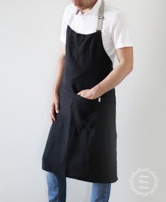 a man in an apron is holding his hand on his hip as he looks down