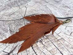 a brown feather keychain on top of a piece of wood