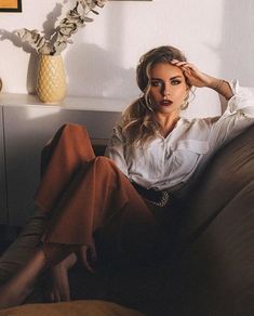 a woman sitting on top of a brown couch