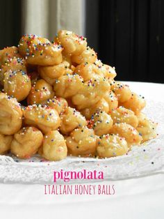 there is a pile of sugar coated doughnuts on a plate with sprinkles