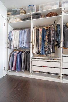 an organized closet with clothes hanging on the shelves and drawers, along with other items