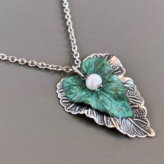 "Leaf Necklace - Layered Mixed Metal Leaves. Larger leaf is Antiqued Silver and smaller leaf is Verdigris Patina Brass. A small White Freshwater Pearl rests in the smaller leaf. Large leaf is just under 1.5\" long x just over 1\" at widest point The patina will vary slightly. This is a stock photo. Stainless Steel Chain Be sure to check out my Verdigris Collection for similar items. http://www.etsy.com/shop/mcstoneworks?section_id=6573408" Patina Jewelry, Mixed Metal Necklace, Silver Metal Clay, Woman Birthday, Dragonfly Bracelet, Jewelry Nature, Dragonfly Jewelry, Metal Clay Jewelry, Steampunk Accessories