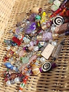 a wicker basket filled with lots of different colored glass and bead items on top of it