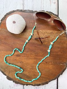 If you're worried about losing your reading glasses or want to add a stylish touch to your sunglasses this summer, this beach inspired glasses chain is perfect for you!  The beaded sunglasses chain is made with ceramic fish beads, starfish beads and glass beads. It has adjustable loops with metal coil that makes it easy to attach to your glasses. This sunglasses strap have adjustable loops with metal coil that makes it easy to attach to your glasses. If you would like, you can easily remove the holder ends from the lobster clasps and wear it as a mask holder. All of BloomingSpringDesign's products are made in a smoke and pet free environment.  They are designed joyfully and delicately produced. My aim is to make you happy with your purchase, so if you are not fully satisfied with them plea Trendy Green Glasses Chains For Beach, Colorful Beaded Glasses Chains For Beach And Summer, Blue Glasses Chains For Beach In Summer, Summer Beaded Glass Chain For Glasses, Blue Glasses Chains For Summer Beach, Beaded Glass Glasses Chains For Beach, Colorful Beaded Glasses Chain For Summer Beach, Beaded Green Glasses Chains For The Beach, Blue Glasses Chains For Beach Summer