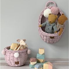 two stuffed animals sitting in a basket next to some wooden blocks and a toy mouse