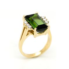 This classic ring is set with a beautiful emerald cut Tourmaline stone, which is dark forest green. It is accented with three round diamonds on either side of the center stone, prong set. The ring is circa the 1970s and in very good condition. [MATERIALS] Stone: Tourmaline (1) Carat: 5.15 Clarity: Eye clean Color: Dark Green Cut: Emerald Setting: Prong Measurement of the stone: 7.70 mm x 13.0 mm Stones: Diamonds (6) Carat: .30 Clarity: SI1 Color: J Cut: Round Setting: prong Metal: approx. 5.70gr Dark Green Ring, Flower Diamond Ring, Ring Emerald Cut, Green Ring, Green Rings, Halo Setting, Ring Emerald, Minimalist Gifts, Tourmaline Stone