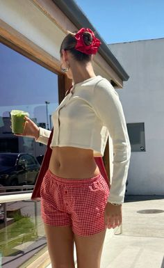 a woman in red and white shorts holding a cup