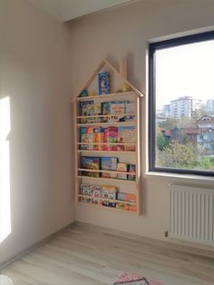 a child's playroom with toys and books on the shelves in front of a window