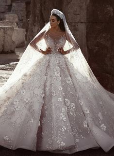 a woman in a wedding dress standing near rocks