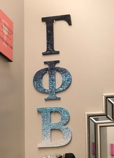 the letters are hanging on the wall in the bathroom, which is decorated with glitter