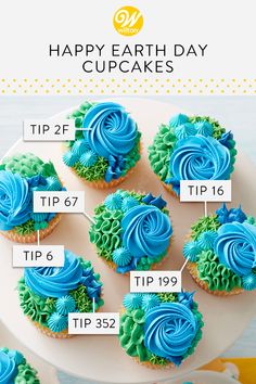 cupcakes with blue and green frosting on a white cake platter that says happy earth day cupcakes