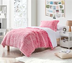 a bedroom with white walls and pink bedding