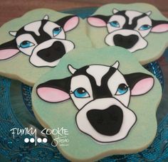 four decorated cookies with blue eyes and black and white dog's face on them