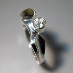 "This ring sports a sparkling white topaz. A very sculptural piece, it can stand alone, or goes quite nicely next to a straight sided band as a wedding set. (4th photo) The white topaz measures 4mm in diameter, and is set in a tube mounting....so there are no prongs to worry about. Done in the lost wax process, this is a stunning \"designer\" ring. Also available in 14k gold. Convo for pricing. Made to order. Allow 2 weeks for delivery. Thanks for looking! Chris" White Topaz Engagement Ring, Topaz Engagement Ring, Everyday Ring, Everyday Rings, Wedding Set, Lost Wax, Ring Sterling Silver, White Topaz, Sterling Ring