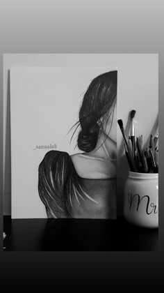 a black and white photo of a woman's back with pencils next to it