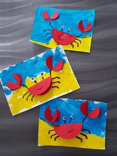 two crab puppets made from construction paper on top of a sheet of blue and yellow