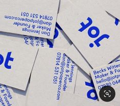 many business cards are stacked together on top of each other, with the letters written in blue