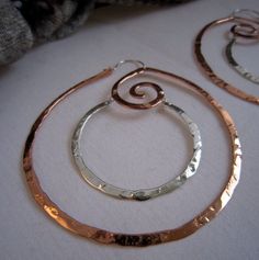 "I love how these strong geometric shapes in two tone metal turned out. Solid bronze swirl hoops with sterling silver center circle make these amazingly light weight high polished textured hoops quite a statement earring. Each component including the sterling silver ear wires are  constructed by hand and connected with sterling silver head pins to give these hoops a clean look.    This post is for one pair of XL hoops in Copper or Bronze with Sterling center hoop. Your choice.  Review from happy Pmc Earrings, Metal Art Jewelry, Wire Jewelry Earrings, Wire Jewelery, Metalsmithing Jewelry, Wire Jewelry Designs, Mixed Metal Jewelry, Crop Circles, Spiral Earrings