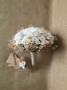 a bouquet of daisies and baby's breath in a vase