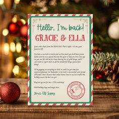 a christmas card with the words grace and ella written on it next to a red ornament