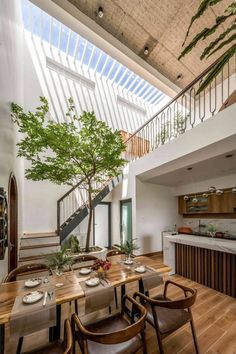 a dining room with wooden tables and chairs next to a tree in the middle of it