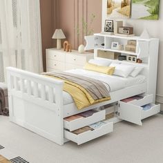 a white bed with drawers underneath it