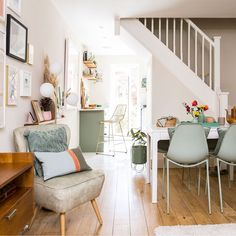 a living room filled with furniture next to a stair case and wooden floored stairs