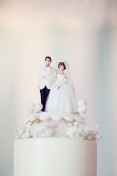 a wedding cake with a bride and groom figurine on top