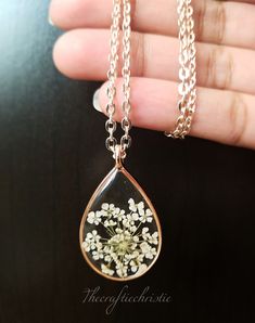 Enjoy this beautiful Queen Anne's Lace flower necklace pressed before encapsulating them with resin in an open back bezel. The necklace includes a 1.75X.75 Inches Rose Gold Teardrop pendant and a beautiful chain. The petals have been carefully preserved to retain their color and would make a great gift for your loved ones.All Jewelry findings are Nickel and Lead Free! This piece was made with real flowers and hence it is important to preserve the jewelry in the box provided safely away from dire Flower Shaped Jewelry With Lobster Clasp For Jewelry Making, Flower-shaped Necklaces With Pressed Flowers For Anniversary, Silver Flower-shaped Resin Necklace, Adjustable Round Pendant With Pressed Flowers, Adjustable Jewelry With Natural Inclusions For Gifts, Handmade Clear Keepsake Jewelry, Teardrop Pressed Flowers Jewelry Gift, Flower Necklace With Lobster Clasp As Gift, Pressed Flowers Jewelry For Gifts