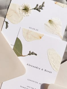 the wedding stationery is laid out on top of each other with leaves and flowers