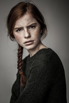 a woman with freckled hair is posing for the camera