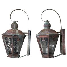 two old fashioned lanterns are hanging on the wall