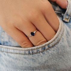 a woman's hand with a ring on her finger and a blue stone in the middle