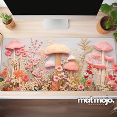 a computer desk with a mouse pad on top of it and various plants in the background