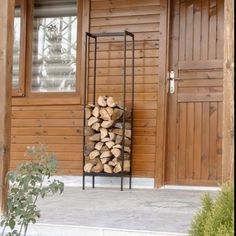 Tall black metal firewood rack holding chopped logs Indoor Firewood Rack, Paver Deck, Storage Fireplace, Firewood Racks, Firewood Holder, Wood Holder, Room Fireplace, Firewood Rack, Log Holder