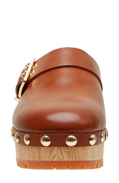 Polished studs and a decorative buckle strap add a moto-chic twist to a classic clog lifted by a wood-grain platform. 2" heel; 1 1/4" platform Slip-resistant sole Leather upper/synthetic lining/rubber sole Imported Moto Chic, 70s Hippie, Wooden Clogs, Clog Heels, Woman Shoes, Womens Clogs, Mule Clogs, Mules Shoes, Stylish Nails