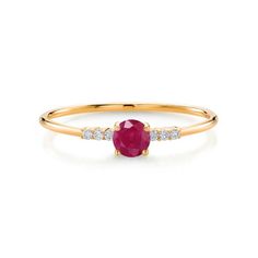 a yellow gold ring with an oval ruby stone and diamonds