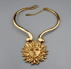 This Vintage Rare YVES SAINT LAURENT Sun Face Necklace is RARE and such a collector item. This was designed by Robert Goossens for YSL and was included in the Metropolitan Arts and Design Museum Exhibition on Fashion Jewelry -- The Collection of BARBARA BERGER. Very classic! A must have. Features: - 100% Authentic YVES SAINT LAURENT. - Adjustable chunky rigid necklace with sun face pendant. - The sun face pendant is intricately detailed, textured and raised. - Signed YSL Made in France. - S and Luxury Vintage Jewelry With Large Stone, Luxury Vintage Jewelry For Rodeo, Luxury Vintage Brass Jewelry, Luxury Artistic Gold Necklaces, Luxury Retro Metal Jewelry, Luxury Art Deco Statement Jewelry, Luxury Bohemian Vintage Jewelry Collection, Luxury Gold Necklace For Fashion Statement, Luxury Vintage Jewelry With Large Pendant