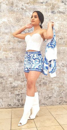 a woman in white top and blue skirt posing