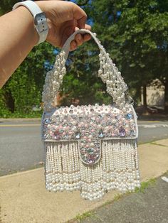 "Premium Quality Heavy Rhinestones Beaded Handmade  Wedding Purse The purse has beautiful beadwork. The purse is made of velvet and heavily beaded with rhinestones all over. The team of artisans has done a fantastic job. These bags are ideal for wedding functions, but you can also have them daily. These are ideal for parties, receptions, and gifts. These are small fancy bags designed for putting money, coins, and make-up touch-up kits.  The bag is heavy and one of a kind. It has a heavily beaded Luxury Beaded Beige Shoulder Bag, Party Embellished Pearl Evening Bag, Pearl White Beaded Evening Bag For Party, Embellished Pearl Bags For Party, Pearl Embellished Bags For Party, White Embellished Evening Bag For Party, Party Pearl Embellished Bags, Pearl Embellished Party Bags, Beaded Pearl Bags For Parties