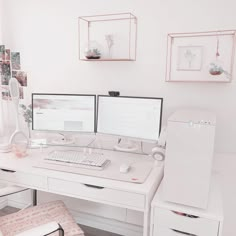 two computer monitors sitting on top of a white desk