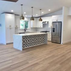 an empty kitchen with white cabinets and stainless steel appliances in the middle of the room