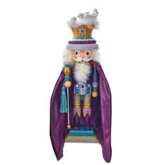 a nutcracker with a purple cape and crown on it's head, standing in front of a white background