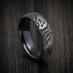 a wedding ring with an intricate design on the inside is sitting on a wooden surface