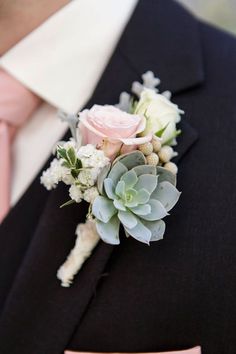 a boutonniere with succulents and flowers on it is worn by a man in a suit